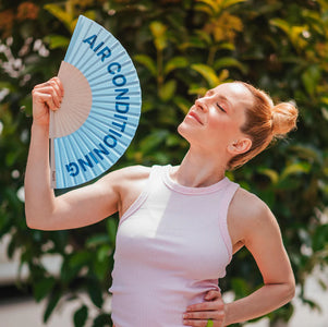 Fisura hand fan shown open with printed design "Air conditioning".