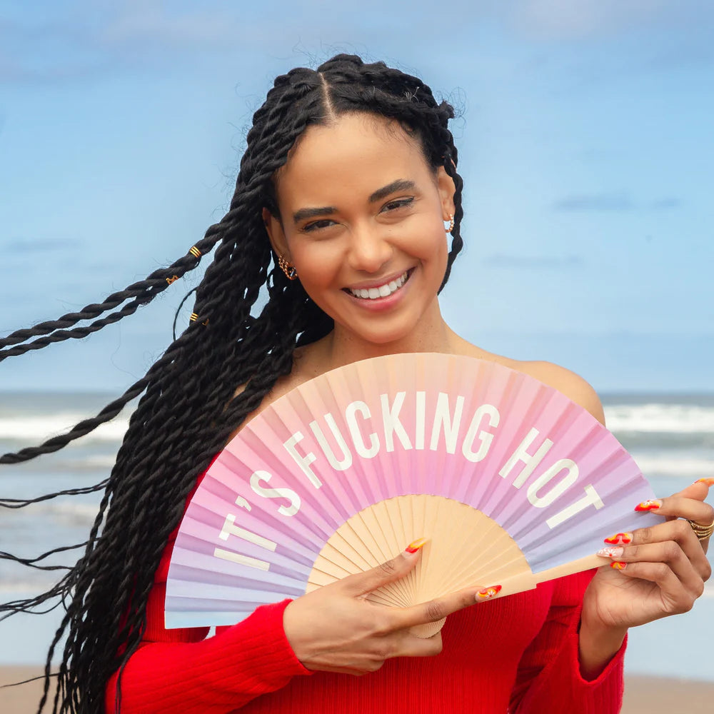 Fun Fisura hand fan shown open with printed design "it's fucking hot".