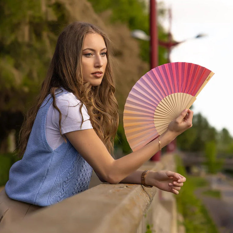 Fisura hand fan shown open with printed design "Sunset"