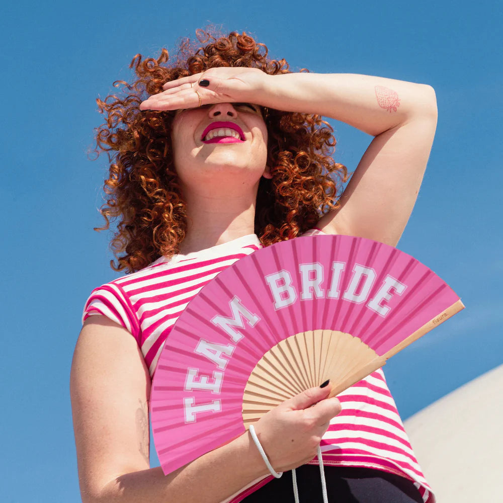 For Bridal parties, Fisura hand fan shown open with printed design "Team Bride" in Pink