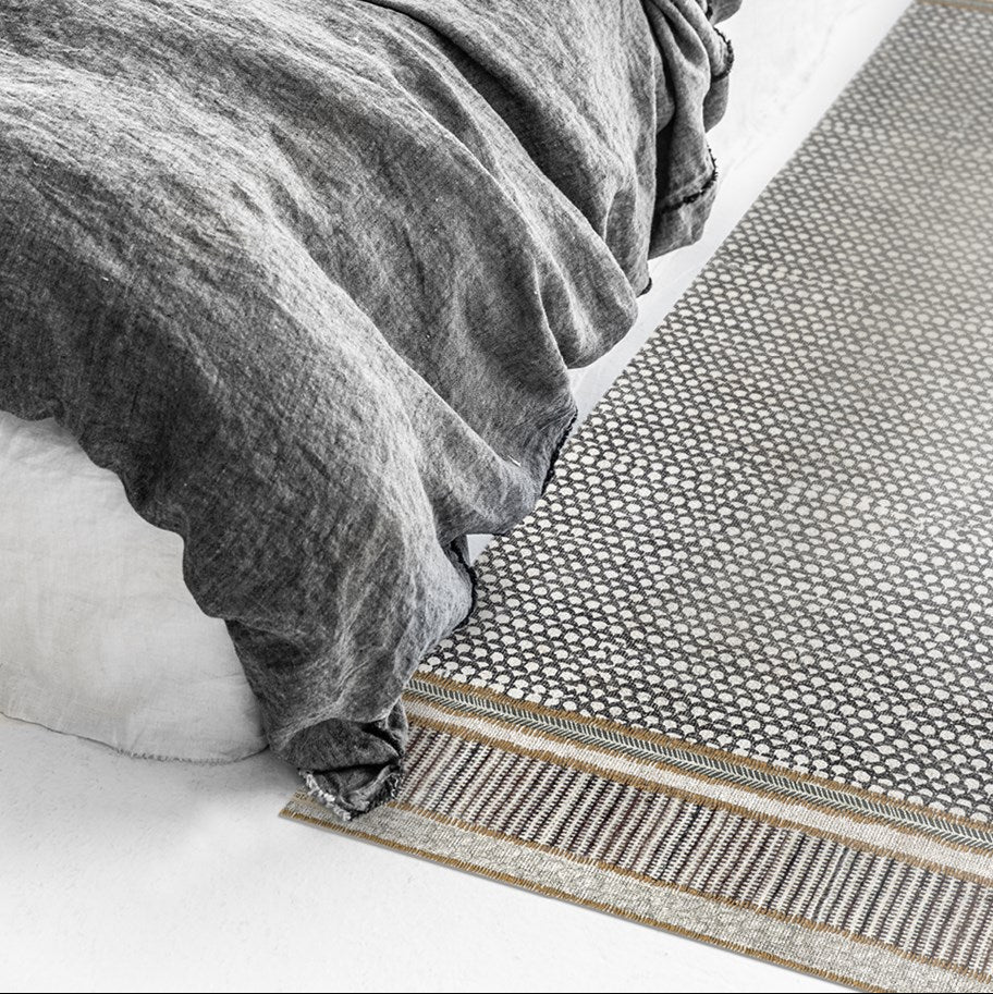 BEIJA FLOR Vinyl Rug- Tribal Scales styled next to a bed