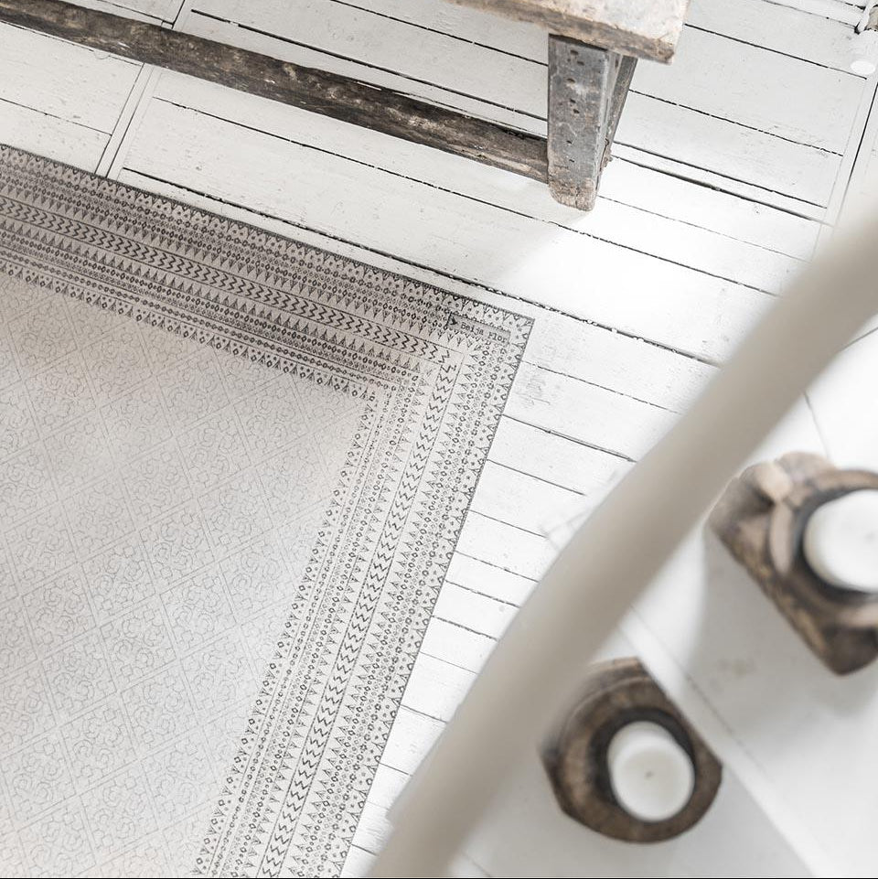 Beija Flor vinyl rug 'Emilia- white' placed on the floor in a styled indoor setting.
