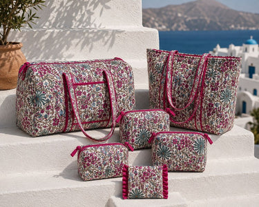 VOYAGE Fleur magenta floral tote bag, weekender bag and set of 3 pouches on a sunny Mediterranean terrace