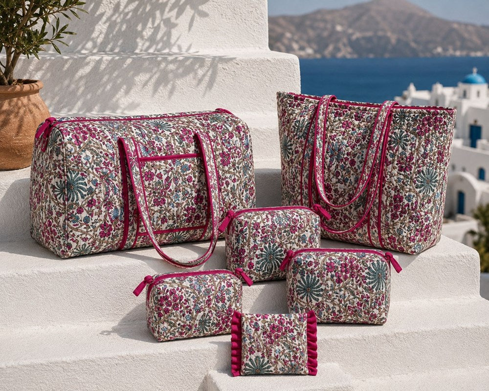 VOYAGE Fleur magenta floral mini ruffle pouch with matching weekender, tote and pouches on a sunny Mediterranean terrace