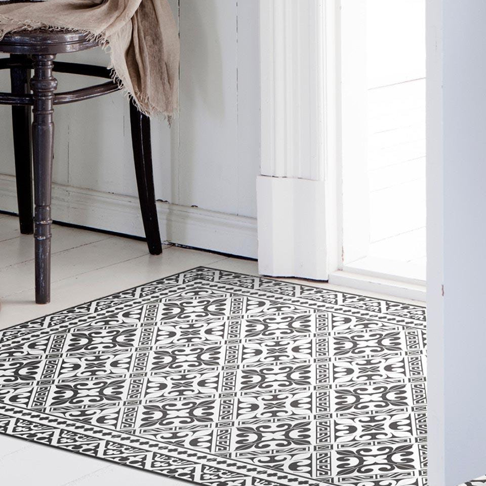 Beija Flor vinyl rug Flor De Lis Black&White placed on the floor in a styled indoor setting.
