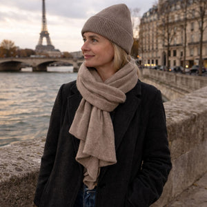 Woman wearing beige knit beanie and scarf outdoors in Paris