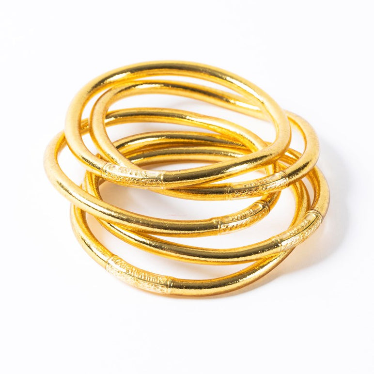 Light gold thick Buddhist bangles stacked together, flexible waterproof bracelets with gold leaf