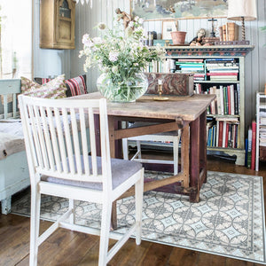 BEIJA FLOR Vinyl Rug- Barcelona Blue under a table