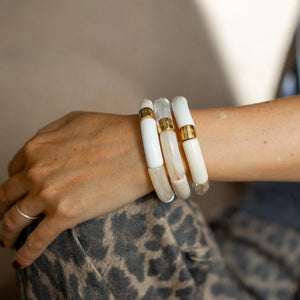 Parabaya cream resin bangle set worn on wrist, featuring soft white & neutral tones with gold-plated details