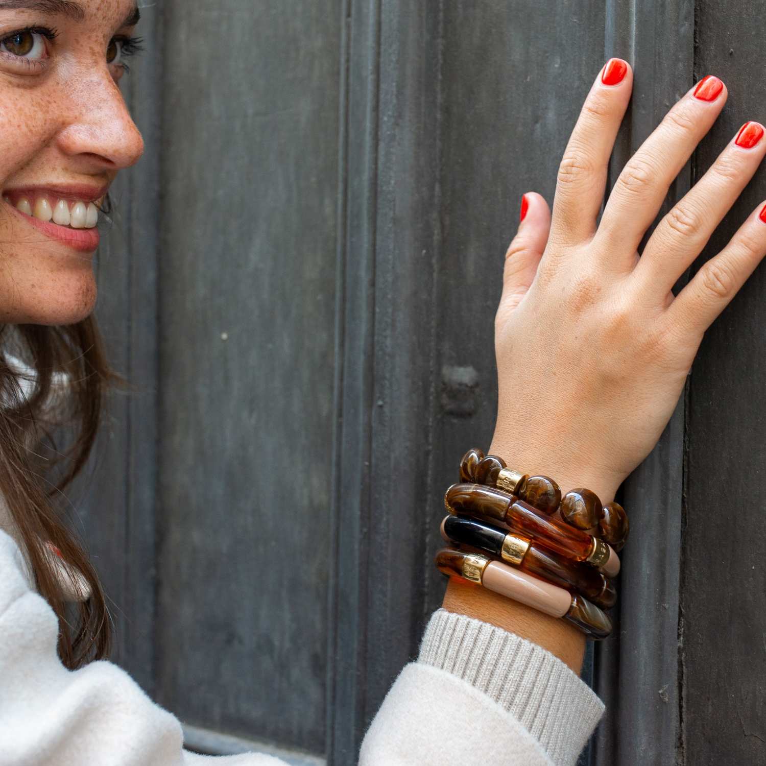 Parabaya Moca resin bangle set worn on wrist, featuring warm brown and amber tones with gold-plated details