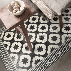 Beija Flor vinyl rug 'Clover Antique' on a floor in a warm interior.
