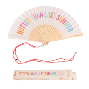 Fisura hand fan shown open, featuring "hotter than last summer" design on bamboo ribs with a cord