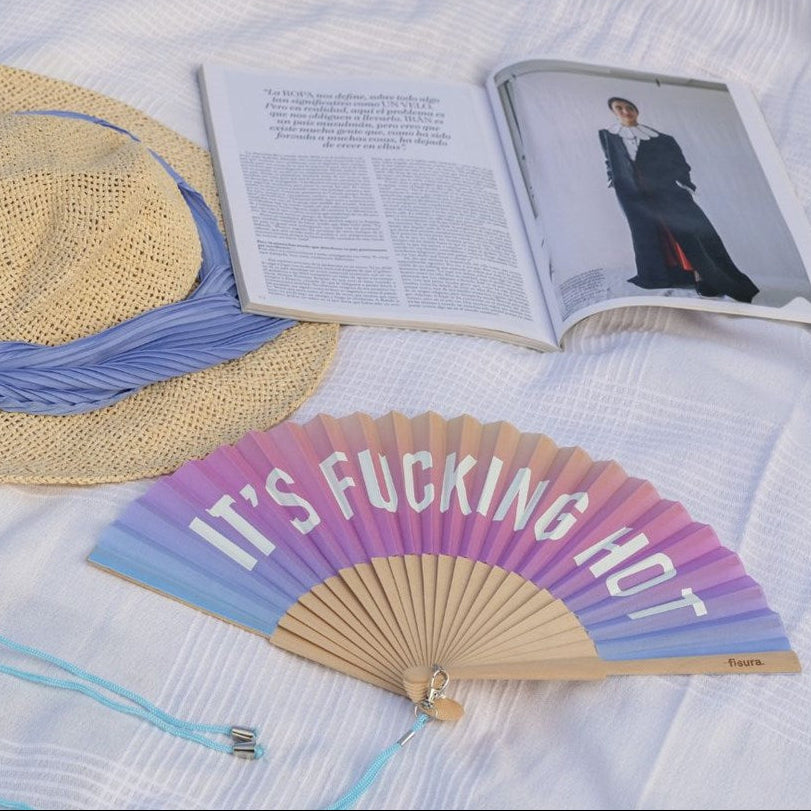 Fisura hand fan shown open with printed design "it's fucking hot".