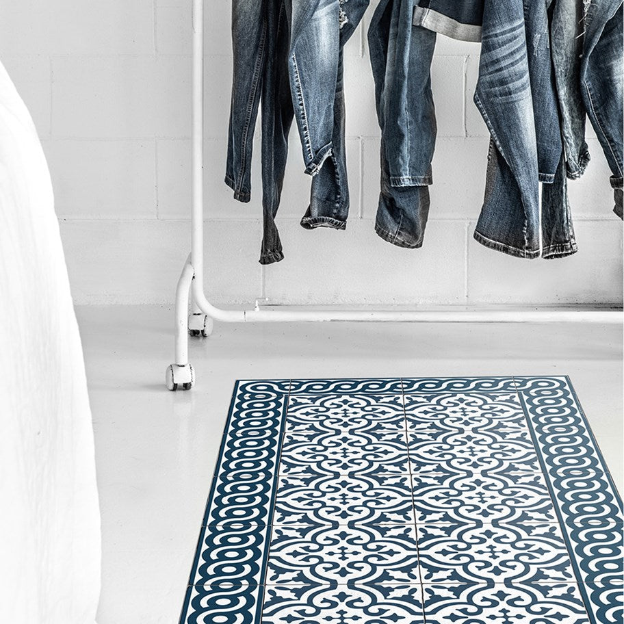 Beija Flor vinyl rug 'Mountain-Indigo' under clothes rack in a styled interior space.